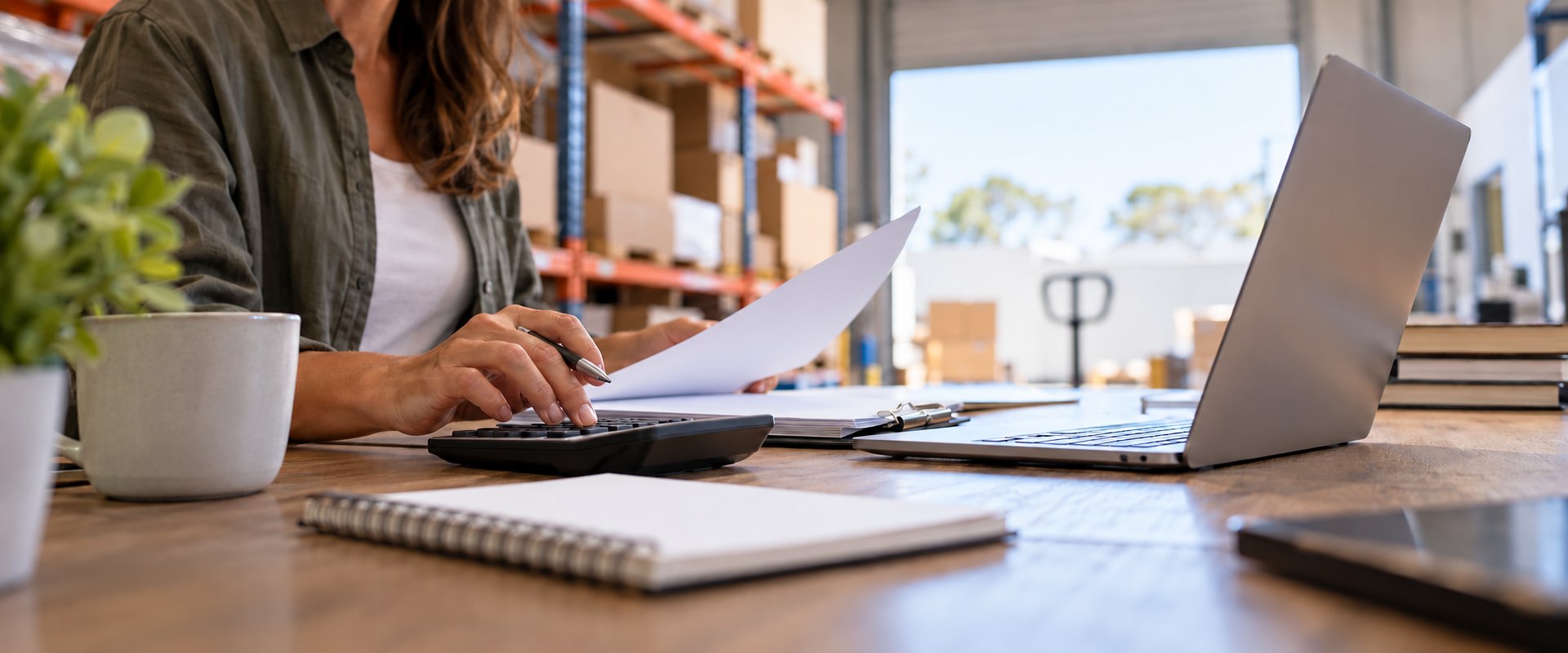 ato debt and business lending - a small business owner reviewing figures in a warehouse office